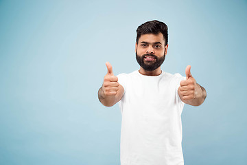 Image showing Half-length close up portrait of young man on blue background.