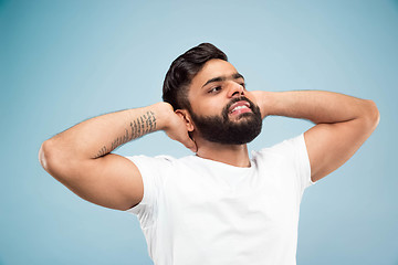 Image showing Half-length close up portrait of young man on blue background.