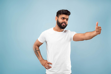 Image showing Half-length close up portrait of young man on blue background.