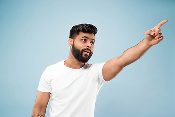 Image showing Half-length close up portrait of young man on blue background.