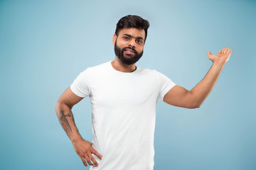 Image showing Half-length close up portrait of young man on blue background.