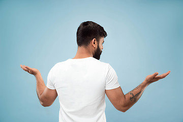 Image showing Half-length close up portrait of young man on blue background.