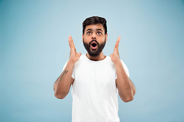 Image showing Half-length close up portrait of young man on blue background.