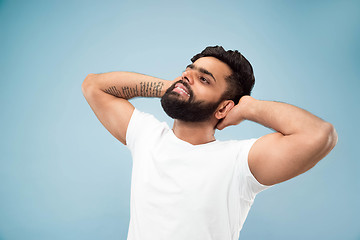 Image showing Half-length close up portrait of young man on blue background.