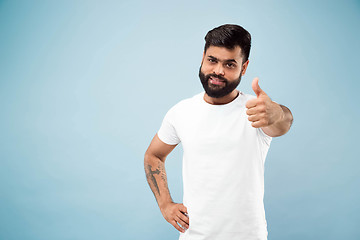 Image showing Half-length close up portrait of young man on blue background.