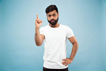 Image showing Half-length close up portrait of young man on blue background.