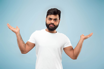 Image showing Half-length close up portrait of young man on blue background.