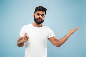 Image showing Half-length close up portrait of young man on blue background.