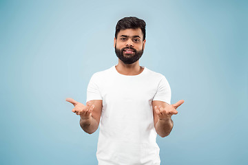 Image showing Half-length close up portrait of young man on blue background.