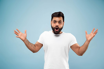 Image showing Half-length close up portrait of young man on blue background.