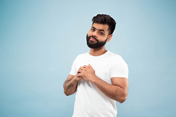 Image showing Half-length close up portrait of young man on blue background.