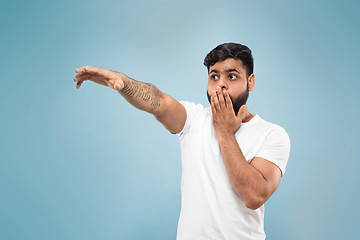 Image showing Half-length close up portrait of young man on blue background.