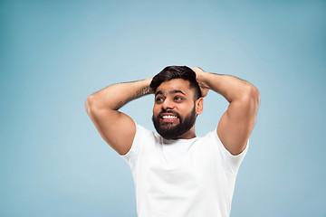 Image showing Half-length close up portrait of young man on blue background.