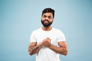 Image showing Half-length close up portrait of young man on blue background.