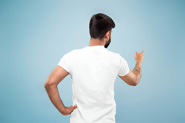 Image showing Half-length close up portrait of young man on blue background.