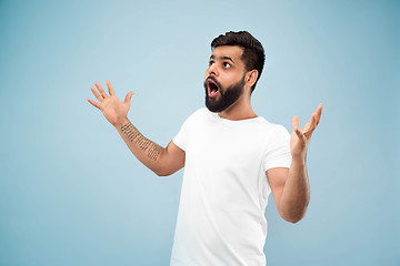 Image showing Half-length close up portrait of young man on blue background.