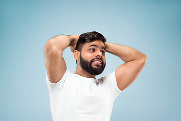 Image showing Half-length close up portrait of young man on blue background.