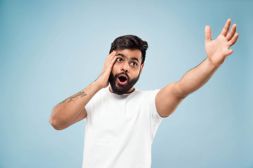 Image showing Half-length close up portrait of young man on blue background.