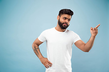 Image showing Half-length close up portrait of young man on blue background.