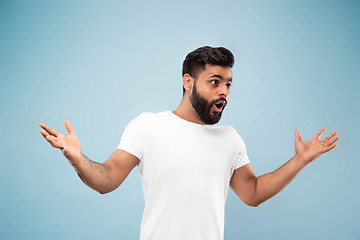 Image showing Half-length close up portrait of young man on blue background.