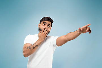 Image showing Half-length close up portrait of young man on blue background.