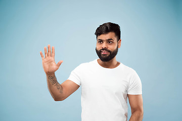 Image showing Half-length close up portrait of young man on blue background.