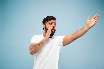 Image showing Half-length close up portrait of young man on blue background.