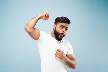 Image showing Half-length close up portrait of young man on blue background.