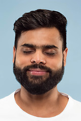 Image showing Close up portrait of young man on blue background.