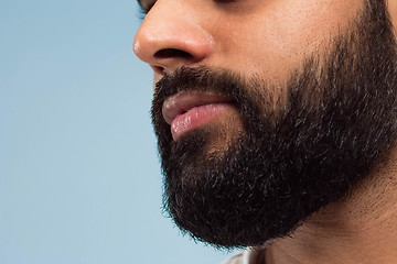 Image showing Close up portrait of young man on blue background.