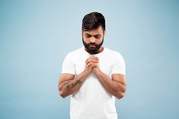 Image showing Half-length close up portrait of young man on blue background.