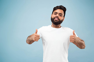 Image showing Half-length close up portrait of young man on blue background.