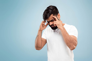 Image showing Half-length close up portrait of young man on blue background.