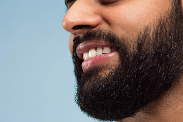 Image showing Close up portrait of young man on blue background.