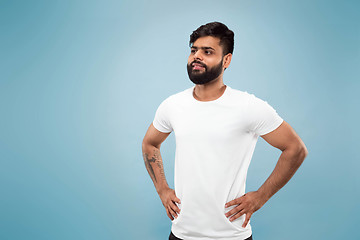 Image showing Half-length close up portrait of young man on blue background.