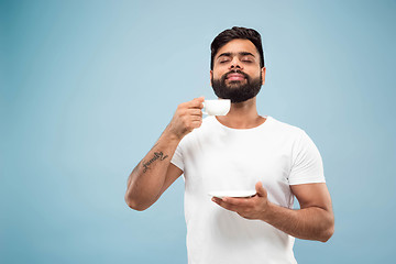 Image showing Half-length close up portrait of young man on blue background.