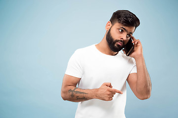 Image showing Half-length close up portrait of young man on blue background.