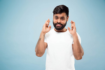 Image showing Half-length close up portrait of young man on blue background.