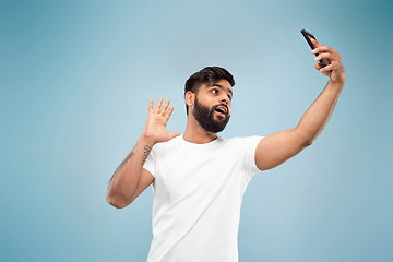 Image showing Half-length close up portrait of young man on blue background.