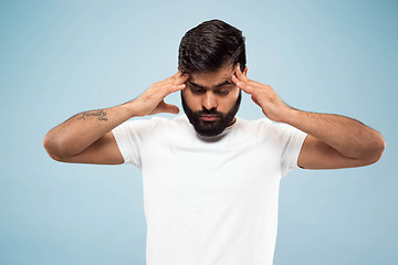 Image showing Half-length close up portrait of young man on blue background.