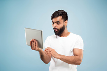 Image showing Half-length close up portrait of young man on blue background.