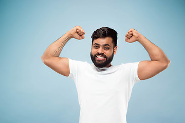 Image showing Half-length close up portrait of young man on blue background.