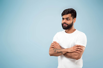 Image showing Half-length close up portrait of young man on blue background.