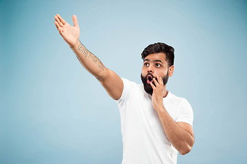 Image showing Half-length close up portrait of young man on blue background.