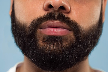 Image showing Close up portrait of young man on blue background.