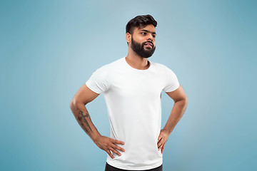 Image showing Half-length close up portrait of young man on blue background.