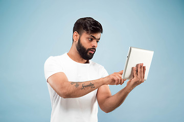 Image showing Half-length close up portrait of young man on blue background.