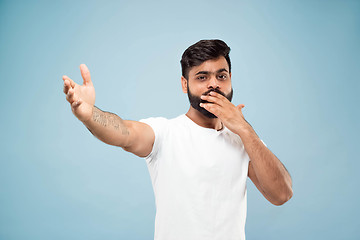 Image showing Half-length close up portrait of young man on blue background.