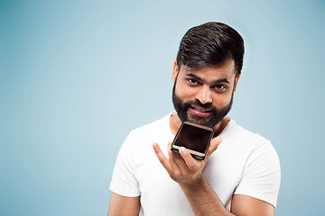 Image showing Half-length close up portrait of young man on blue background.