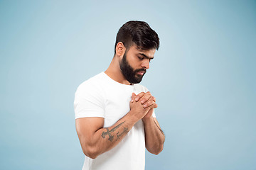 Image showing Half-length close up portrait of young man on blue background.